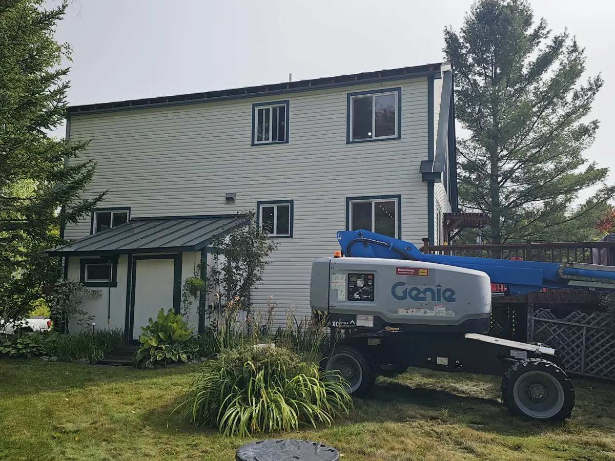 During: old fascia removed, boom lift set up beside the house